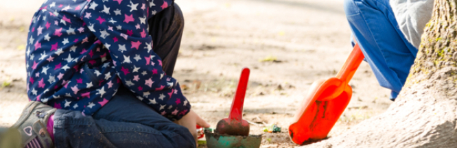Zwei Kinder spielen im Garten mit Sandspielsachen