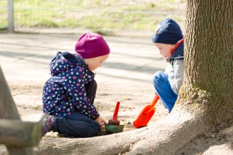 Zwei Kinder spielen im Garten mit Sandspielsachen
