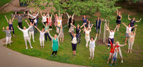 Mitglieder des ThEKiZ-Teams im Kita-Garten beim public viewing recken ihre Arme triumphierend in den Himmel