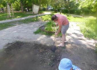 Auf dem Bild sind Ein Erwachsene und ein Kind beim Umgraben zu sehen