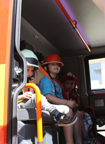 Auf dem Bild sind einige Kinder im Feuerwehrauto zu sehen