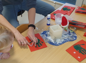 Ein Kleinkind am Tisch mit Weihnachtskarten