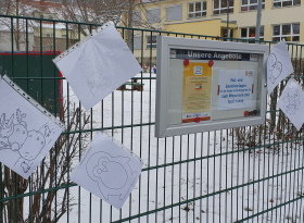 Der Zaun vor der Kita mit einem Schaukasten und vielen Ausmalvorlagen 